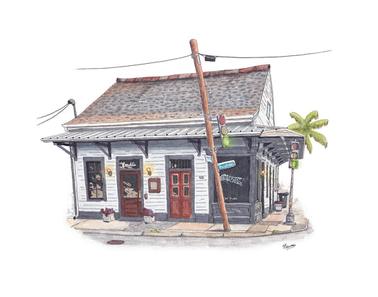 A product photo shows an example of The Local Commission Art process. A classic New Orleans style gray building with charcoal trim sits on a street corner with a leaning light pole having a traffic light affixed to it just in front of the building. A palm tree is in the distance behind the building. A golden evening light hits the roof. This building was the former restaurant and bar called The Franklin on Franklin Ave in the Marigny neighborhood of New Orleans.